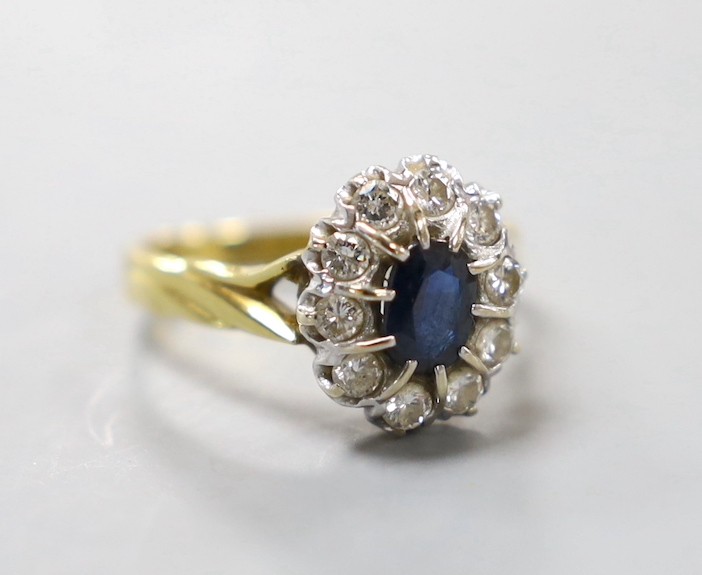A modern 18ct gold, sapphire and diamond set oval cluster ring, size L, gross weight 4.6 grams.